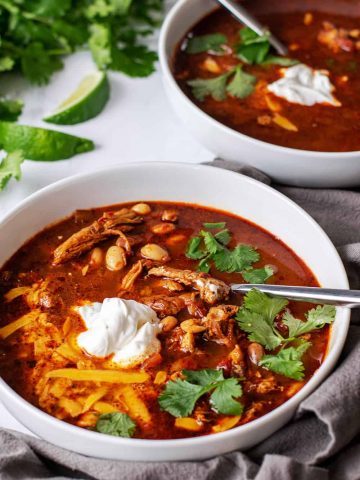 bowl of Slow Cooker White Bean Chicken Chili with sour cream, cilantro, and cheddar cheese