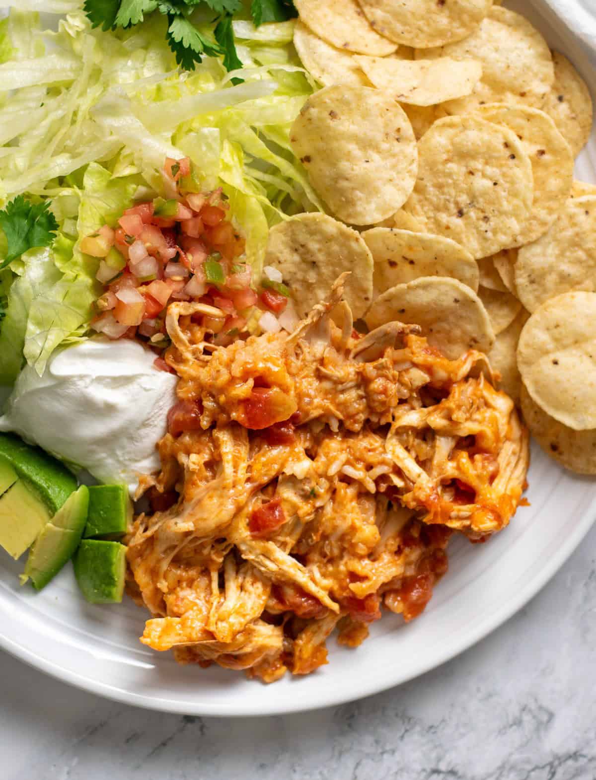 Cheesy Mexican Chicken and Rice Bake served with chips, sour cream and avocado