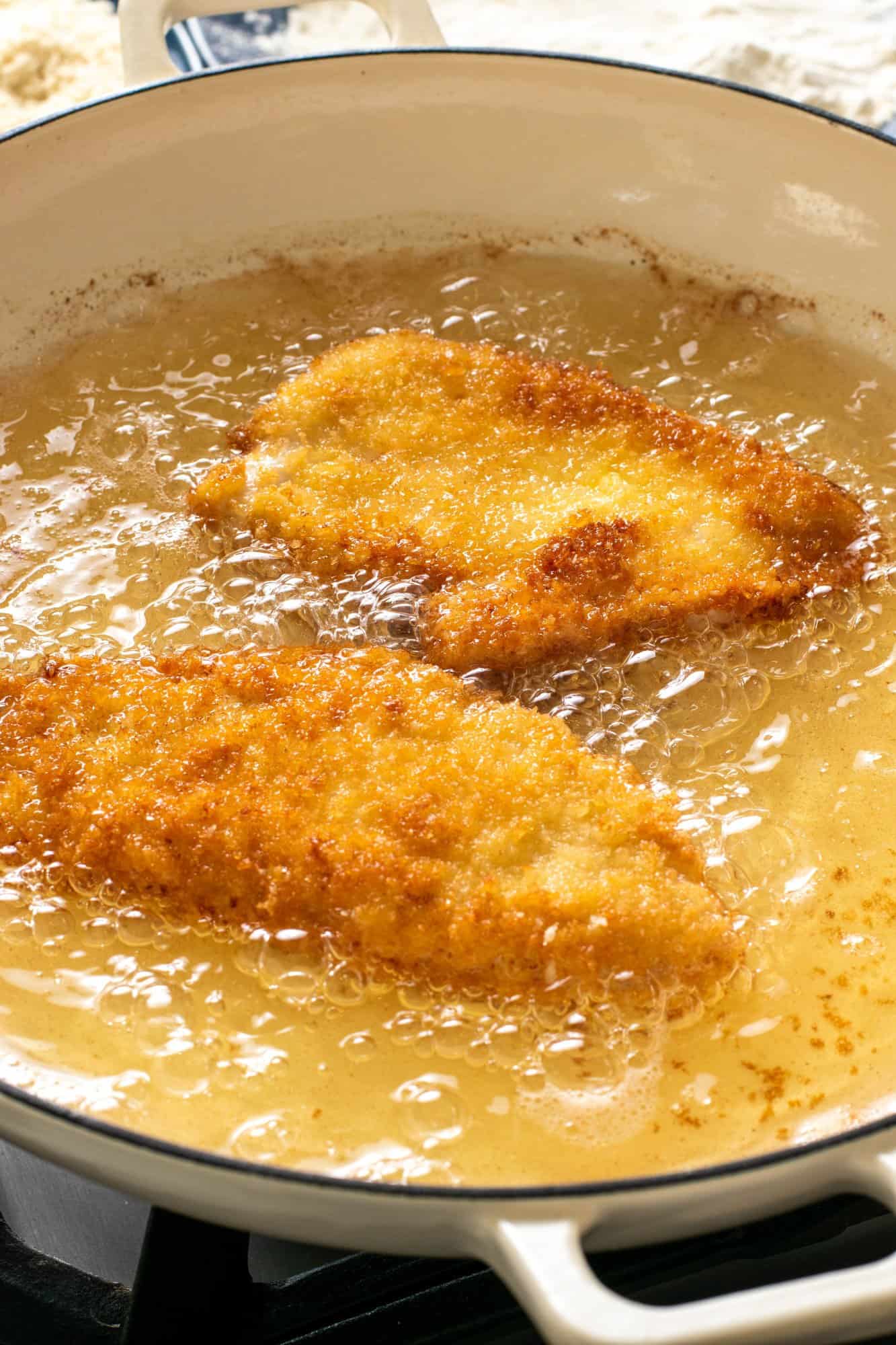 chicken cutlets frying in oil