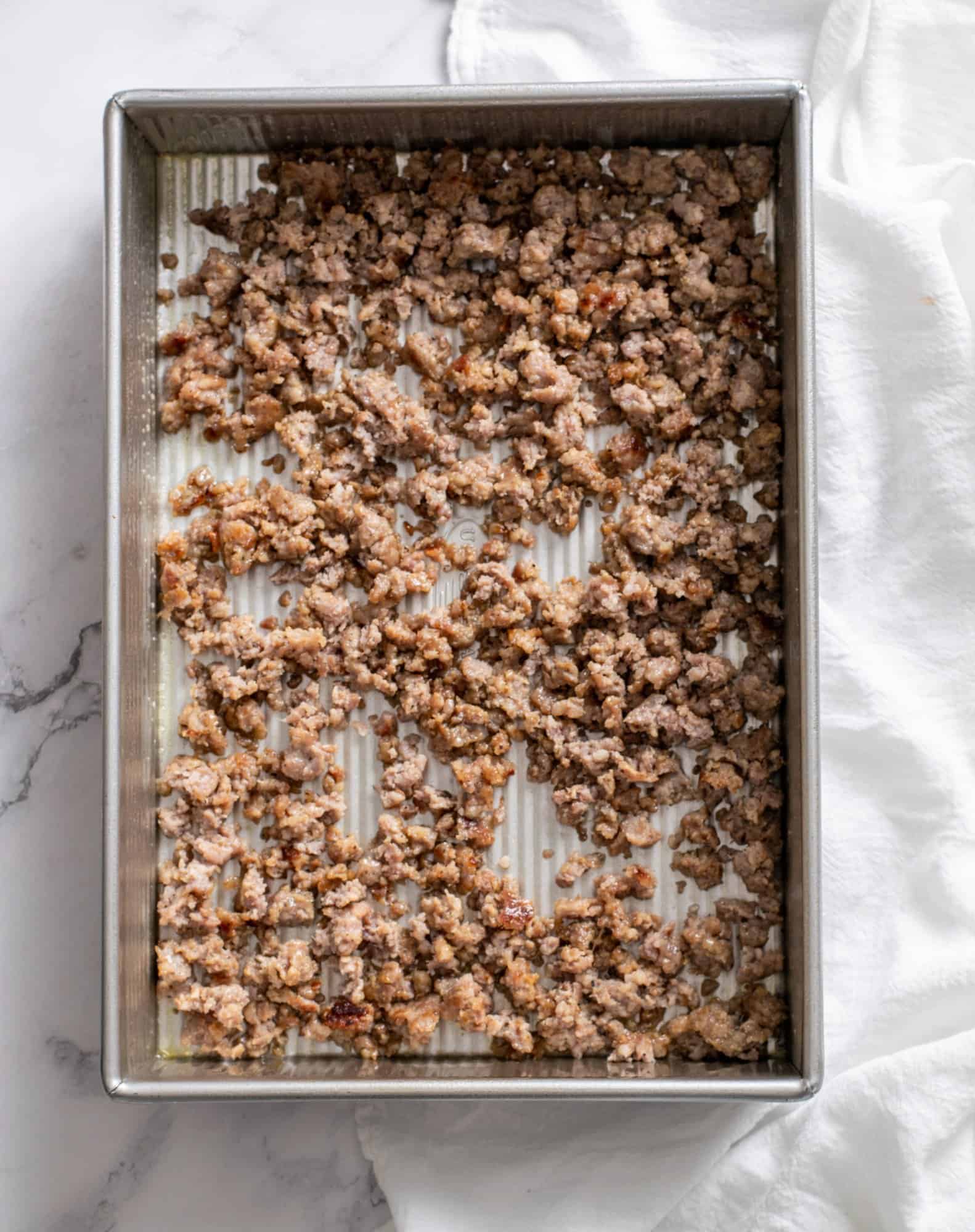 crumbled cooked sausage in the bottom of the pan