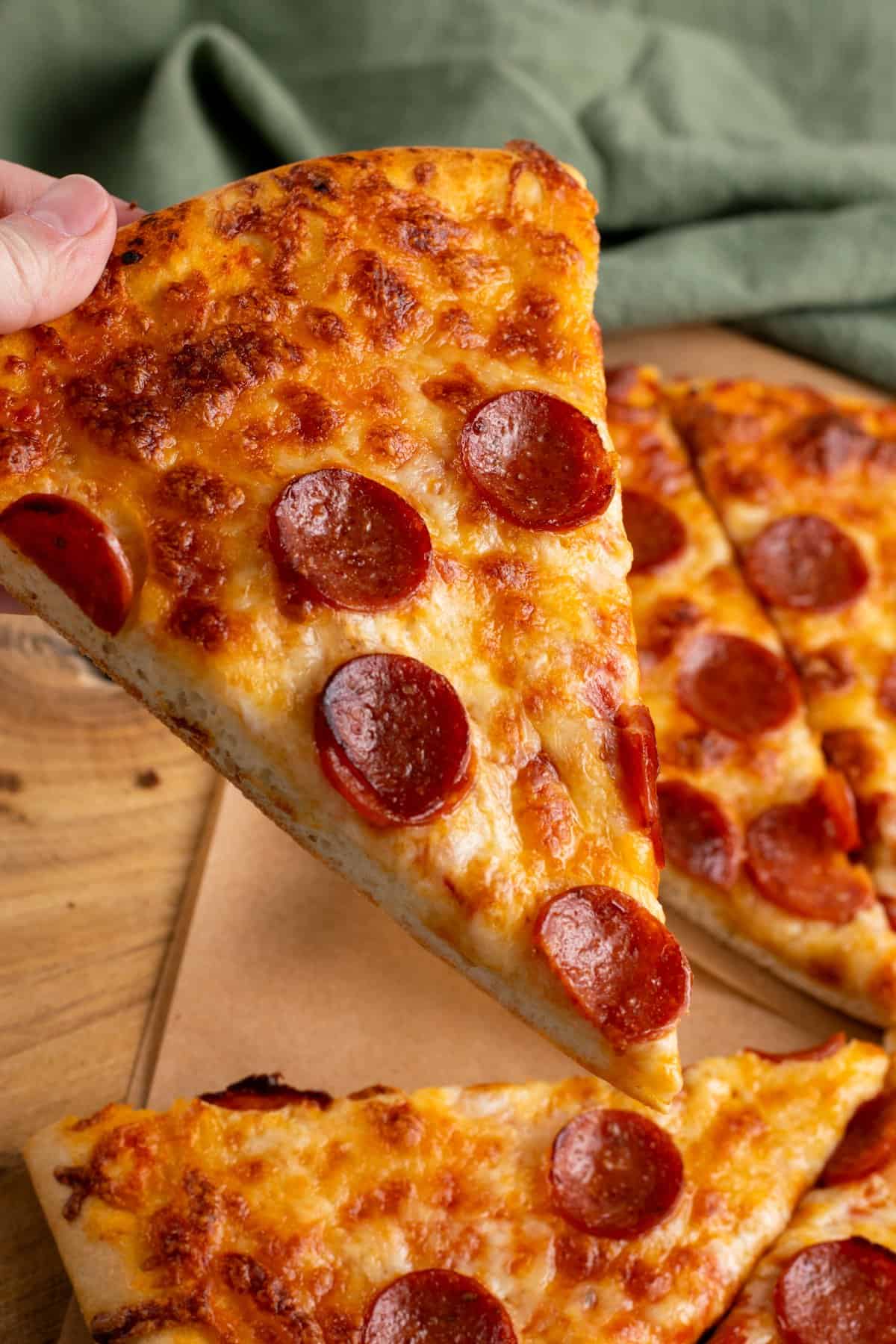 hand holding a slice of pizza